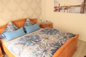 a bedroom with a large wooden bed with blue pillows at Catalena in Radolfzell am Bodensee