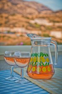 einen Glaskasten und zwei Gläser auf dem Tisch in der Unterkunft Aegean Sea in Lefkos Karpathos