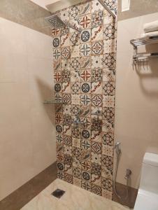La salle de bains est pourvue d'une douche et d'un mur en carrelage. dans l'établissement RiomarBR, à Panaji
