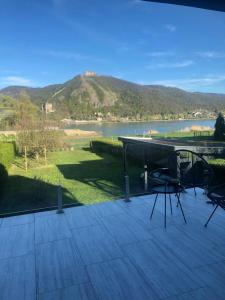 a deck with a table and chairs and a lake at Fotel Dunakanyar in Nagymaros