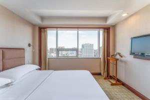 a hotel room with a bed and a large window at Baoding Zhong Yin Hotel in Baoding