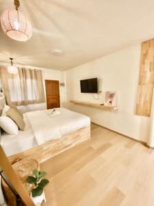 1 dormitorio con 1 cama y TV de pantalla plana en The O room, en Koh Larn