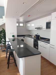 a kitchen with white cabinets and a black counter top at Golf Lake Penthouse in As Sīfah