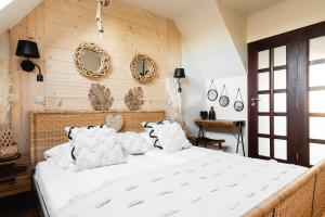 a bedroom with a large white bed with pillows at Apartament Aspekt Zakopane in Zakopane