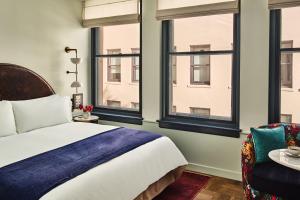 sypialnia z łóżkiem, krzesłem i oknami w obiekcie Hotel Per La, Autograph Collection w Los Angeles