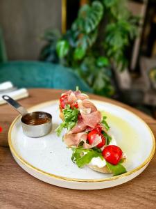 a plate of food with a sandwich on a table at Hotel Estera in Krakow