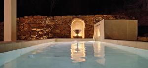 una piscina de agua con una pared de piedra en Las estrellas del duende, en El Gastor