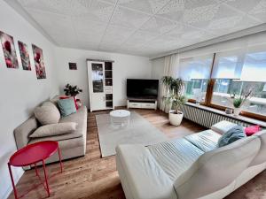 a living room with a couch and a tv at Ferienwohnungen Auf der Höhe in Engelsbrand