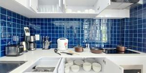 uma cozinha com lavatório e azulejos azuis na parede em Green Lung Pool Villas Bangkok em Bang Krasop