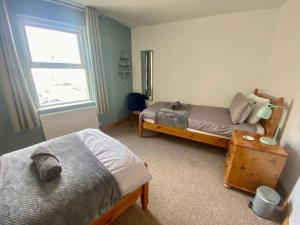 a bedroom with two beds and a window at Ballycastle Modern Town House in Ballycastle