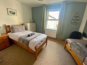 a bedroom with two beds and a window in it at Ballycastle Modern Town House in Ballycastle
