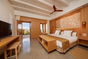 a bedroom with a bed and a flat screen tv at Finca Sestelrica in Artá