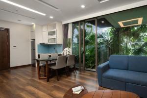 - un salon avec une table et un canapé bleu dans l'établissement Flamingo Dai Lai Resort - Hotel & Villas- by Bay Luxury, à Phúc Yên