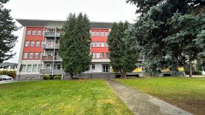 a large building with trees in front of it at 2 room Apartment - Apartmány Chopok in Liptovský Mikuláš