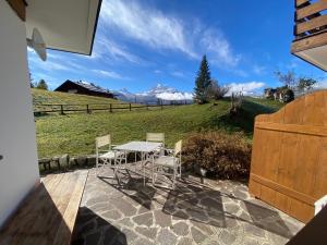 a table and chairs on a patio with a view at FALORIA APARTMENT-splendid view in Cortina dʼAmpezzo