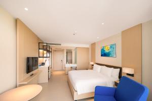 une chambre d'hôtel avec un lit et une chaise bleue dans l'établissement Sea view at The Arena Cam Ranh resort, Bai Dai beach, near airport Nha Trang, Khanh Hoa, à Thôn Hòa Ða