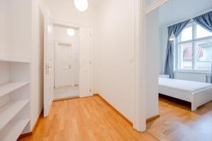 a white room with a bed and a window at Hotel U 3 Pstrosu in Prague