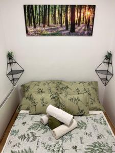 1 cama con 2 almohadas y una foto en la pared en Bükk Apartman Bükkszentkereszt, en Bükkszentkereszt
