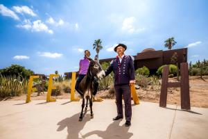 een man en een vrouw die naast een ezel staan bij Fellah Hotel in Marrakesh