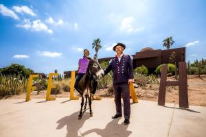 a man and a woman standing next to a donkey at Fellah Hotel in Marrakesh