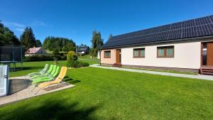 a yard with two chairs and a house at Apartmány U Potoka in Dolní Moravice