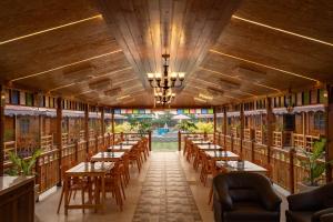 an empty restaurant with wooden tables and chairs at Grace Exotica Goa in Canaguinim