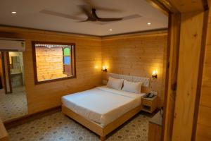 a bedroom with a bed and a window and a ceiling at Grace Exotica Goa in Canaguinim