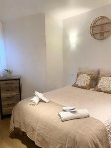 ein Schlafzimmer mit einem Bett mit zwei Handtüchern darauf in der Unterkunft La Petite Vernoelle in Prémilhat