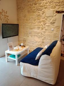 a bedroom with a bed and a table with a tv at Le Cosy Cabarieu in Saint-André-de-Cubzac