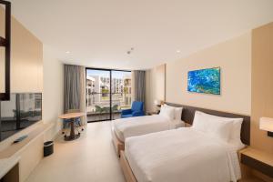 Habitación de hotel con 2 camas y ventana en Ocean view at The Arena Cam Ranh resort, Bai Dai beach - near Airport Nha Trang, Khanh Hoa en Cam Lâm