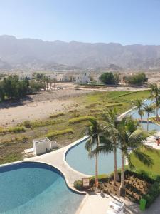 z góry widok na ośrodek z basenem i palmami w obiekcie Golf Lake Penthouse w mieście As Sifah