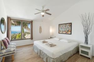 a white bedroom with a bed and a window at Bed & Breakfast in Villa Eden Palm in Benalmádena