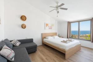 a bedroom with a bed and a couch and a window at Bed & Breakfast in Villa Eden Palm in Benalmádena