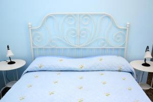 ein blaues Schlafzimmer mit einem Bett mit einem Kopfteil aus Metall in der Unterkunft Casa Giordano in Tramonti