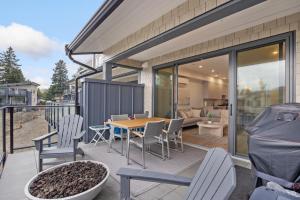a patio with a table and chairs and a couch at Coastal Haven at THE BEACH HOUSE in Campbell River