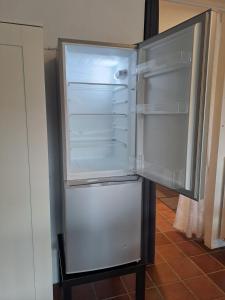 um frigorífico vazio com a porta aberta numa cozinha em STUDIO Wohnung 34m², Kreuzbergl (1-2 Gäste) em Klagenfurt