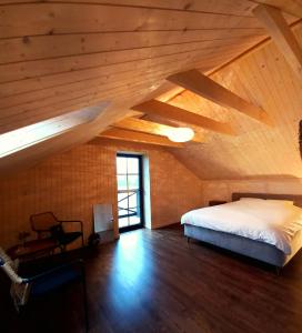 a bedroom with a bed and a wooden ceiling at Namelis Gluosnė in Rusnė