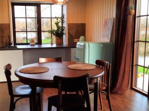 a kitchen with a wooden table and a refrigerator at Namelis Gluosnė in Rusnė +7 photos