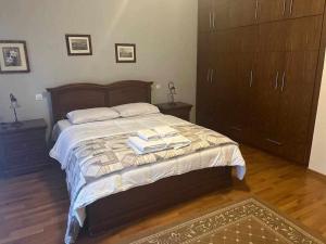 sypialnia z dużym łóżkiem, drewnianą podłogą i szafkami w obiekcie Το σπίτι του Μύλου των Ξωτικών w mieście Tríkala