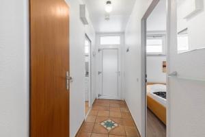 einen Flur mit Tür und Bett in einem Zimmer in der Unterkunft Baltic Whg 26 in Grömitz