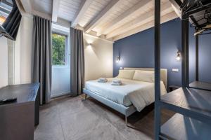a bedroom with a bed with a blue wall at La Casa Incartata - Carta da Zucchero in Toscolano Maderno