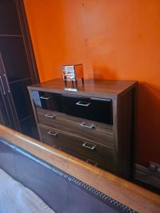 a wooden dresser sitting next to a bed at The Margaret Residence in Bexhill