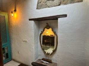 um espelho no lado de uma parede com uma mesa em Balcon de los Amorosos em Castellar de la Frontera
