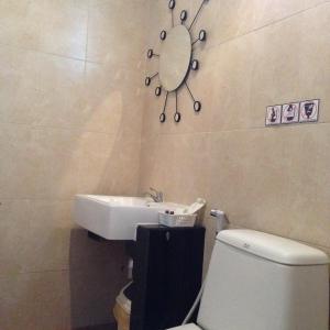 a bathroom with a sink and a toilet and a mirror at เดอะวิลล่า71 รีสอร์ท in Ban Zong Katiam