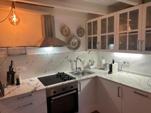 uma cozinha com bancadas de mármore branco e um lavatório em Balcon de los Amorosos em Castellar de la Frontera