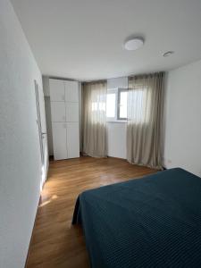a bedroom with a bed and a wooden floor at Moderne Einliegerwohnung am Park in Weingarten
