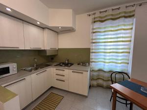 ベルガモにあるComfort Accommodation Residenceの小さなキッチン(白いキャビネット付)、窓