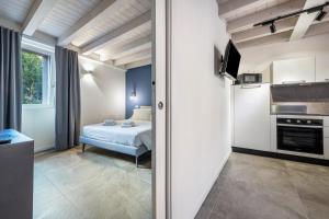 1 dormitorio pequeño con 1 cama y cocina en La Casa Incartata - Carta da Zucchero, en Toscolano Maderno