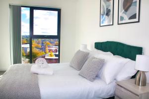 a bedroom with a white bed with a large window at AP- Luxury Apt nxt to o2 Academy in Birmingham