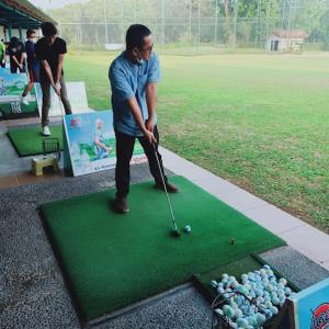 a man playing golf on a putting green at WKNDR Zone in Jakarta